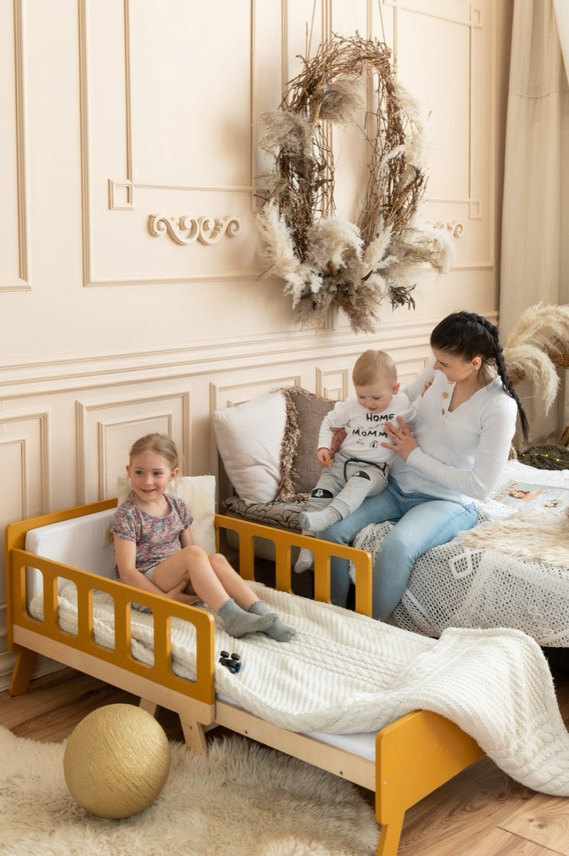 Family on mustard yellow Family-scl growing kids bed – adjustable children's bed in cozy nursery room