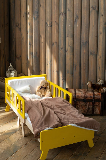 Bright yellow Family-scl extendable kids bed with teddy bear – wooden growing bed for toddlers