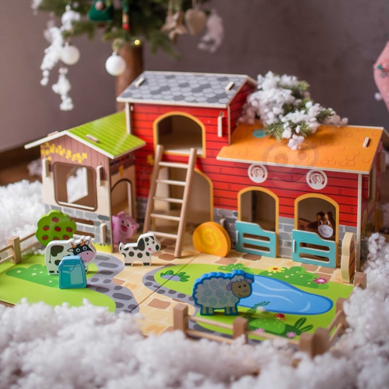 Complete wooden farm playset with barn, chicken coop, animals, and fencing on green base with holiday decor