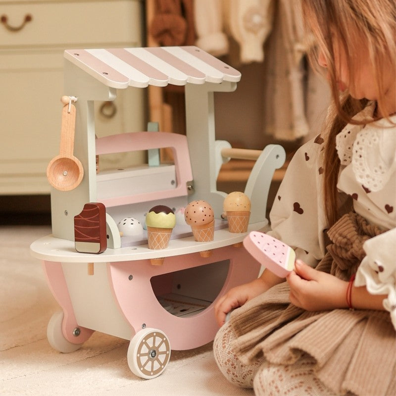 Girl playing with pink and white wooden ice cream cart with pastel scoops
