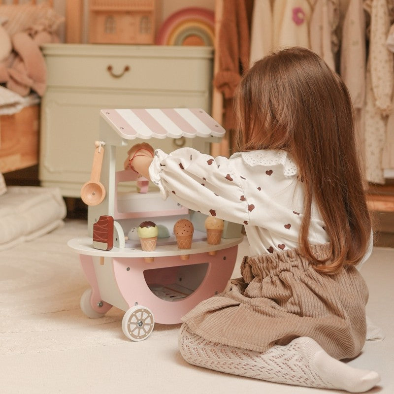 Child scooping wooden ice cream from cart display during playtime