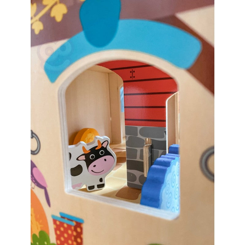 Close-up of wooden stable door with cow figurine inside barn structure showing interior details