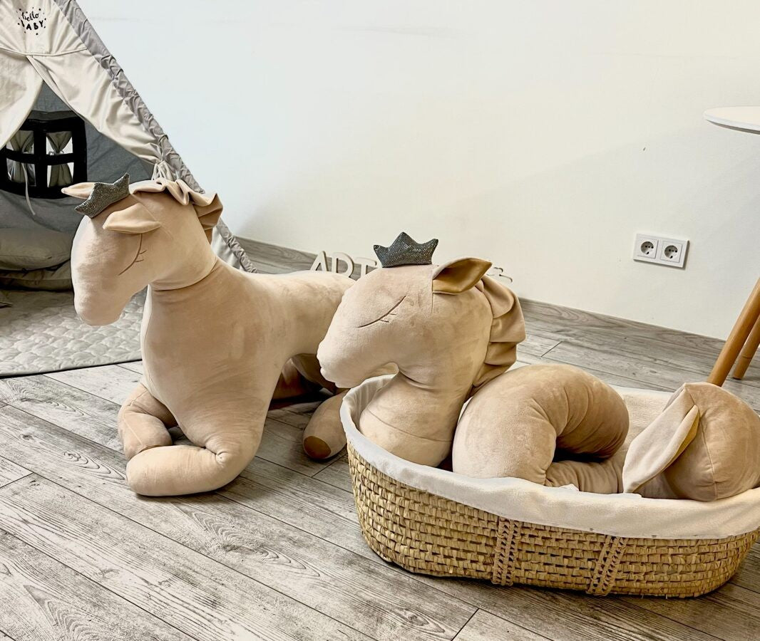 Two creamy velvet pegasus toys displayed on floor, one in wicker basket