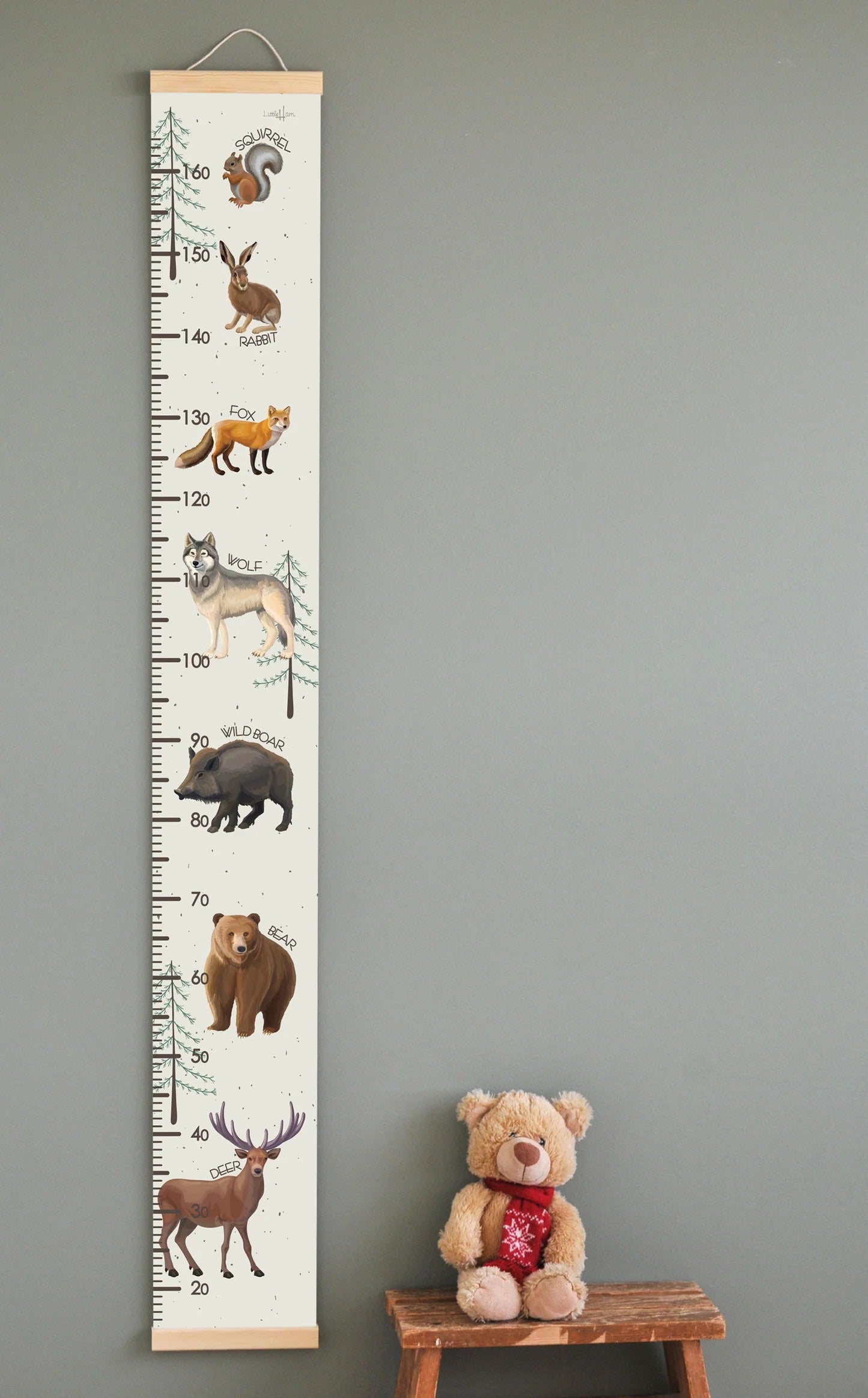 Wild animals growth chart hanging on wall with measurement scale, featuring illustrated raccoon, rabbit, fox, wolf, boar