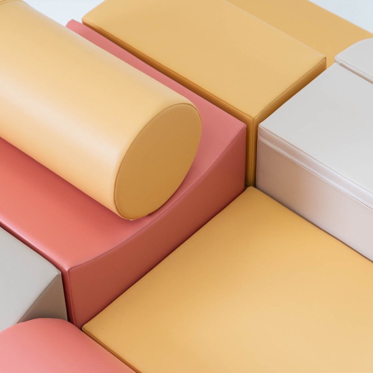 Close-up of foam cylinder and rectangular blocks showing pastel pink and yellow foam material