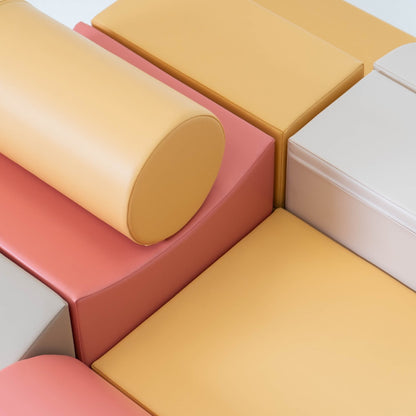 Close-up of foam cylinder and rectangular blocks showing pastel pink and yellow foam material