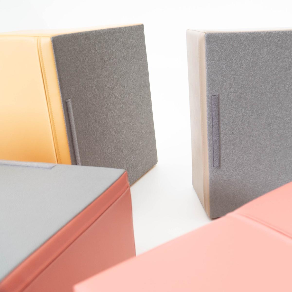 Detail view of foam block edges showing pastel pink binding and gray foam surface texture
