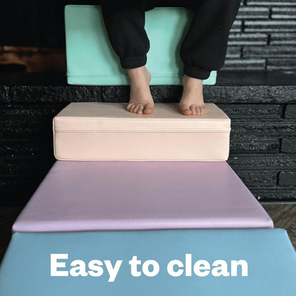 Child's bare feet on stacked foam blocks demonstrating easy-to-clean surface