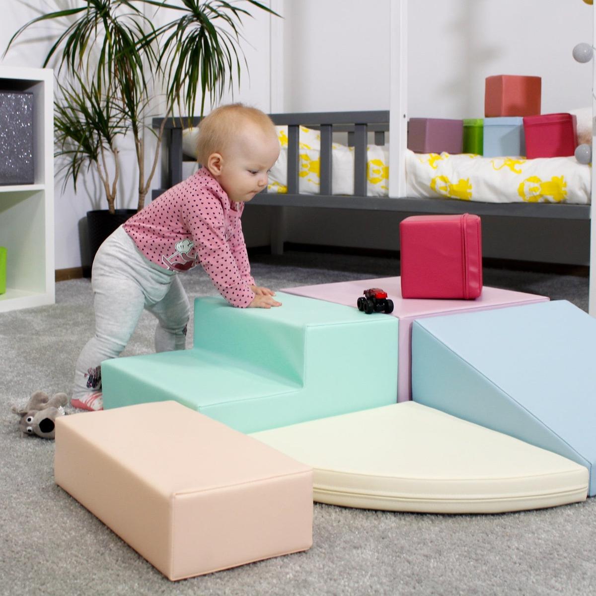 Baby playing with pastel foam climbing blocks indoors