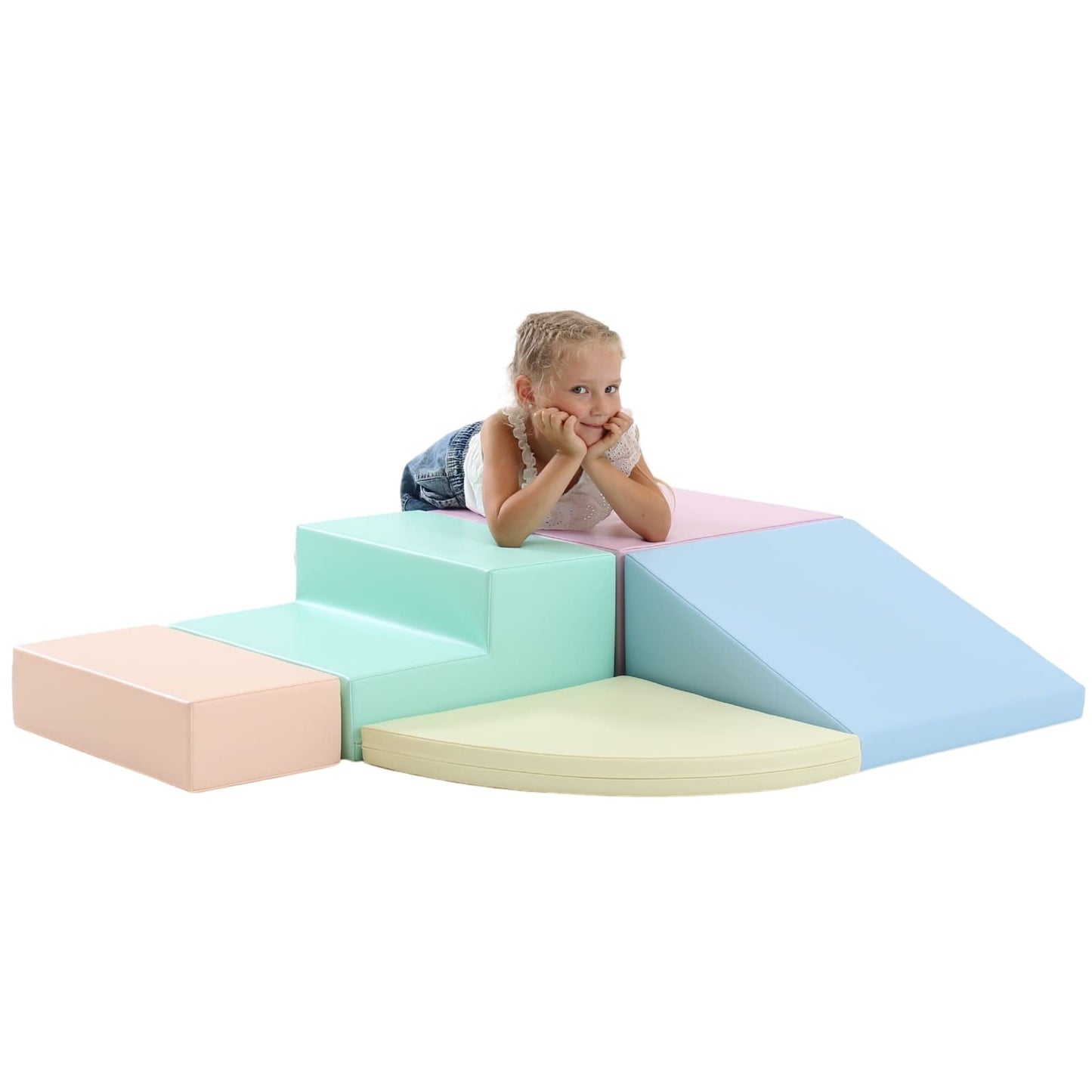 Older child lying on pink pastel foam block during playtime