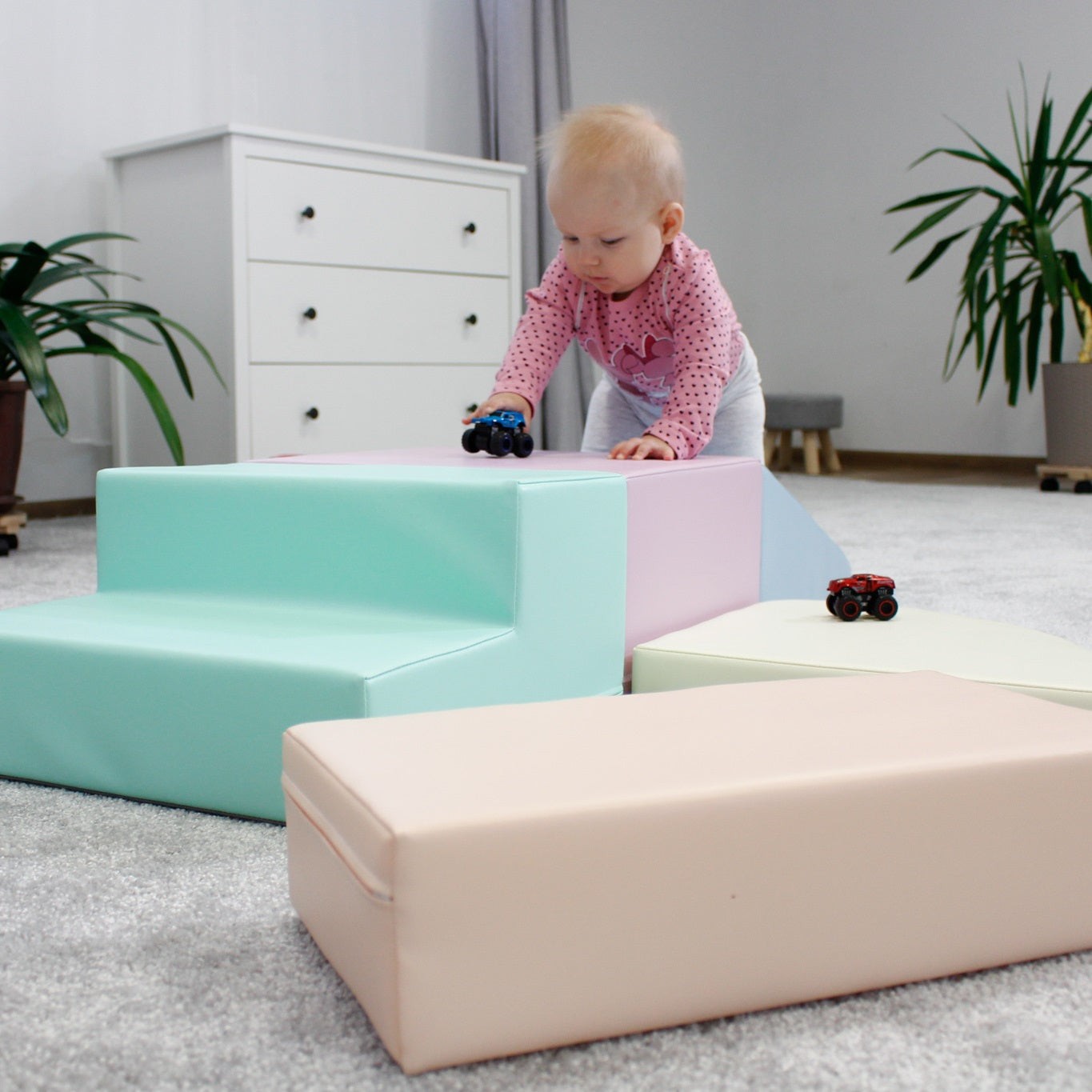 Toddler climbing over light pastel corner climber foam block set