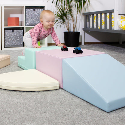 Baby crawling on pink and mint pastel foam blocks in playroom