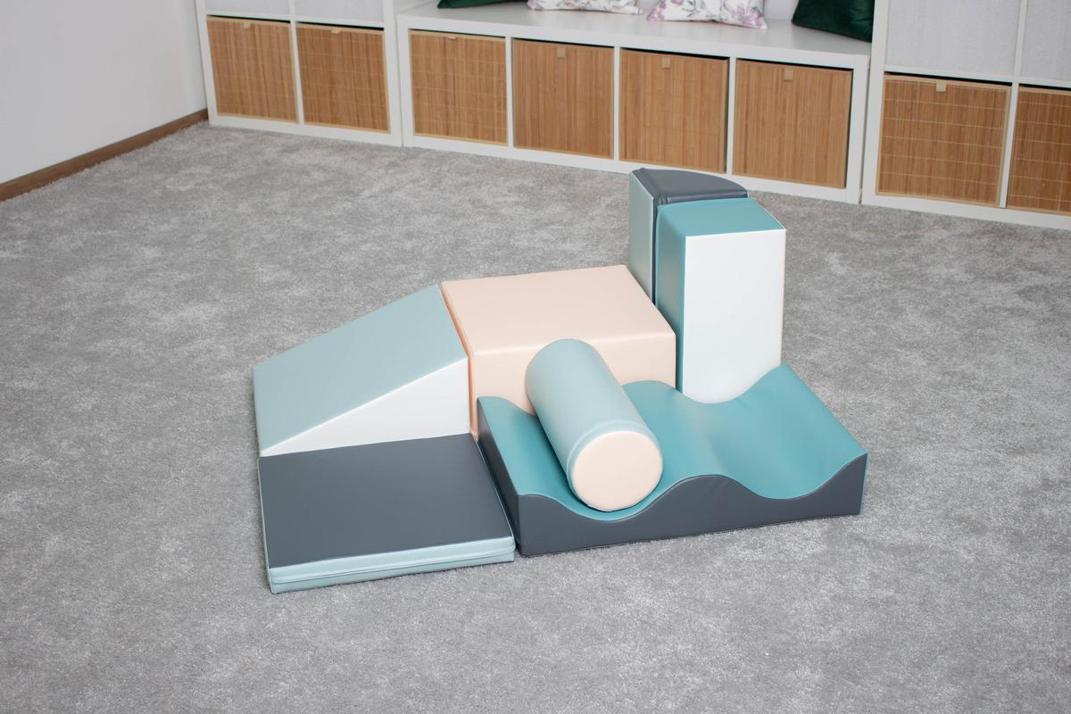 Light pastel foam play blocks arranged on gray floor in playroom