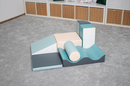 Light pastel foam play blocks arranged on gray floor in playroom