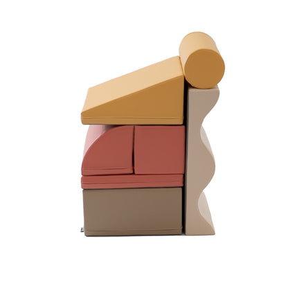 Side profile of stacked foam blocks showing pink, red, beige and gray colors with cylinder roll on top