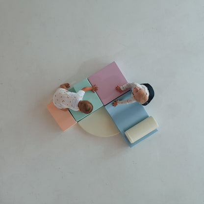Overhead view of toddler playing with light pastel foam blocks and cylinder