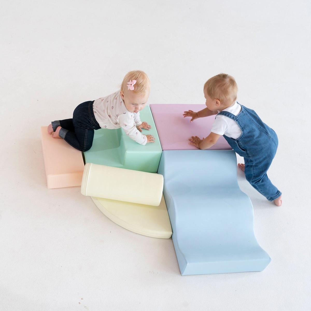 Assembled light pastel foam blocks displayed outdoors on wooden deck