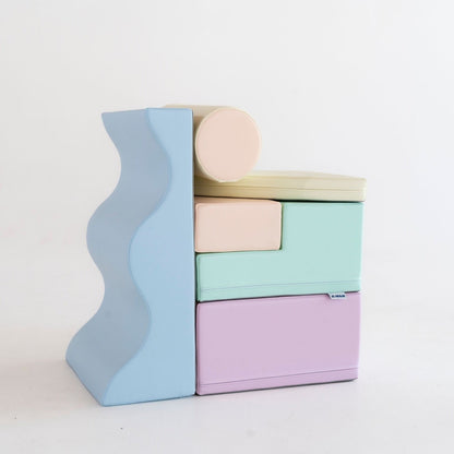 Toddler crawling on light pastel foam blocks in living room playspace