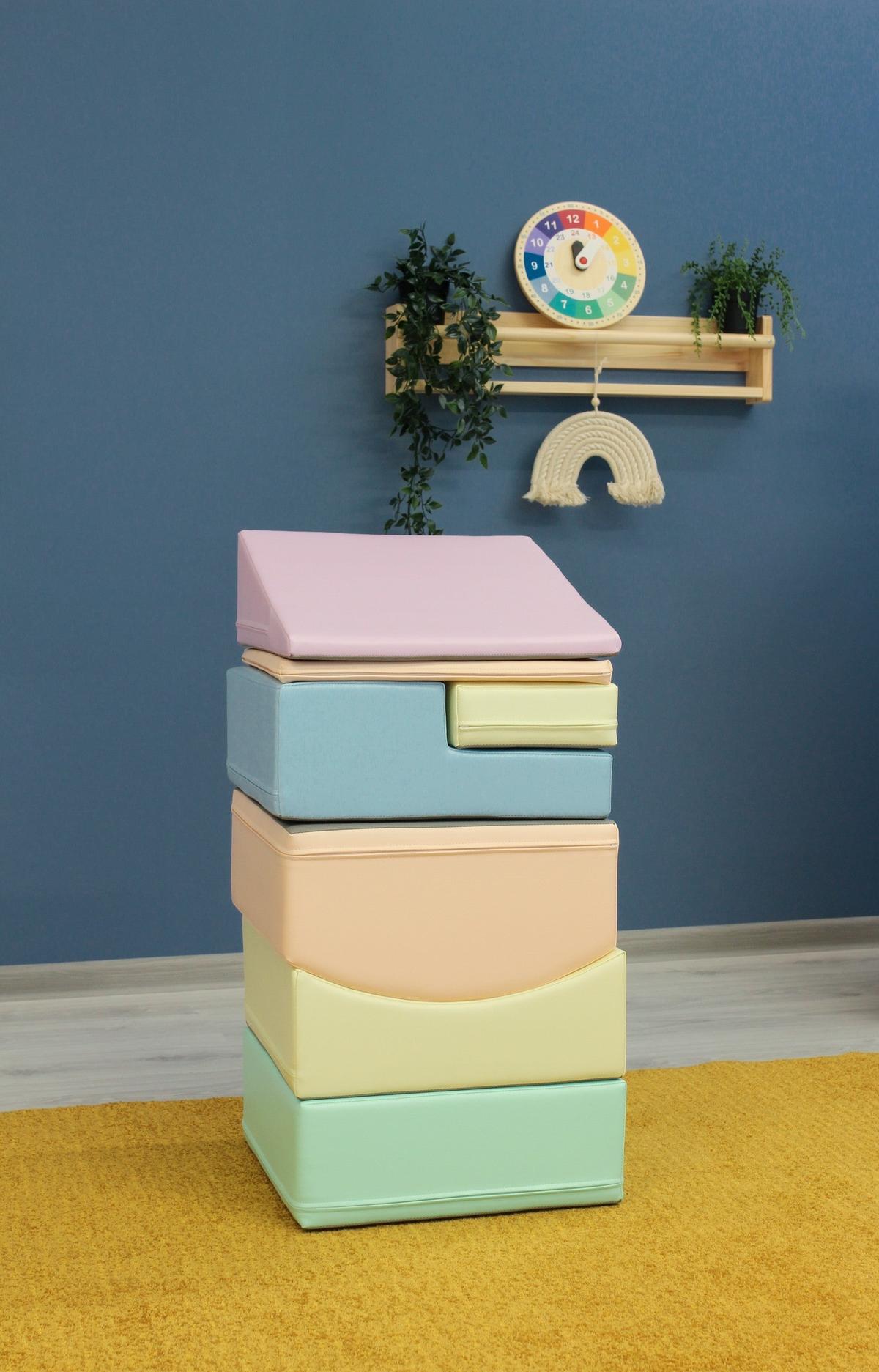 Toddler crawling over pastel foam climbing blocks in playroom setting