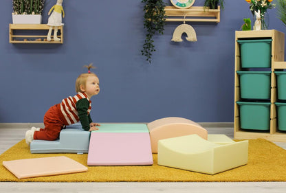 Stacked pastel foam blocks in light pink, mint, cream, and yellow arranged vertically