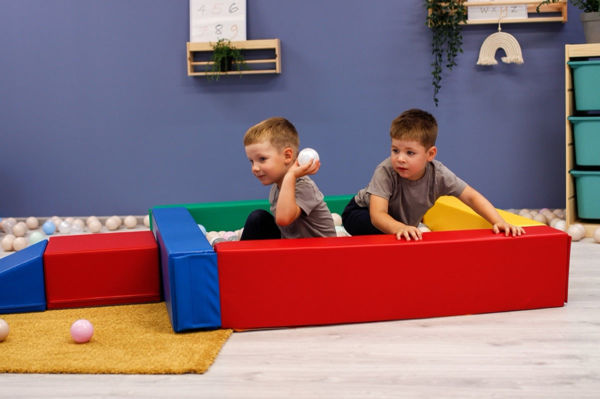 Two children playing in IGLU soft play ball pit indoors – multicolor foam sensory play area