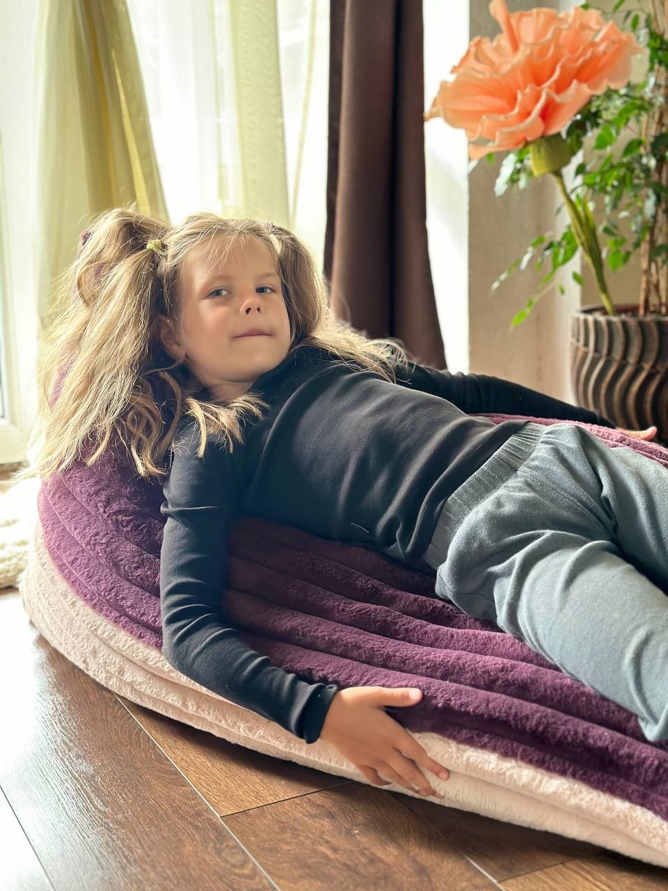Child lounging in soft ribbed plush beanbag with mousse and berry color blocks