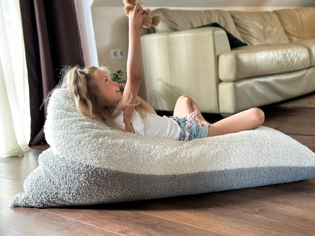 Girl relaxing on plush sherpa bean bag reading while lying down