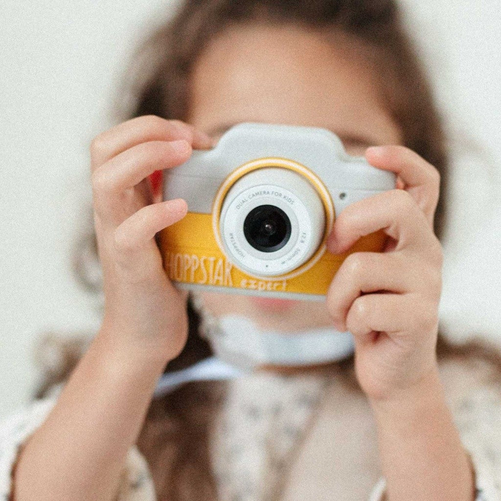 Girl taking a photo with the yellow Hoppstar Expert Citron kids camera