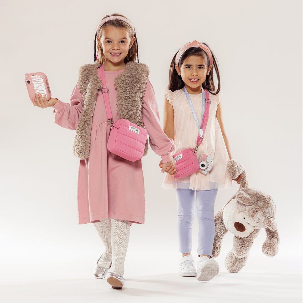 Two girls in pink with the Hoppstar Expert Blush camera and a pink bag