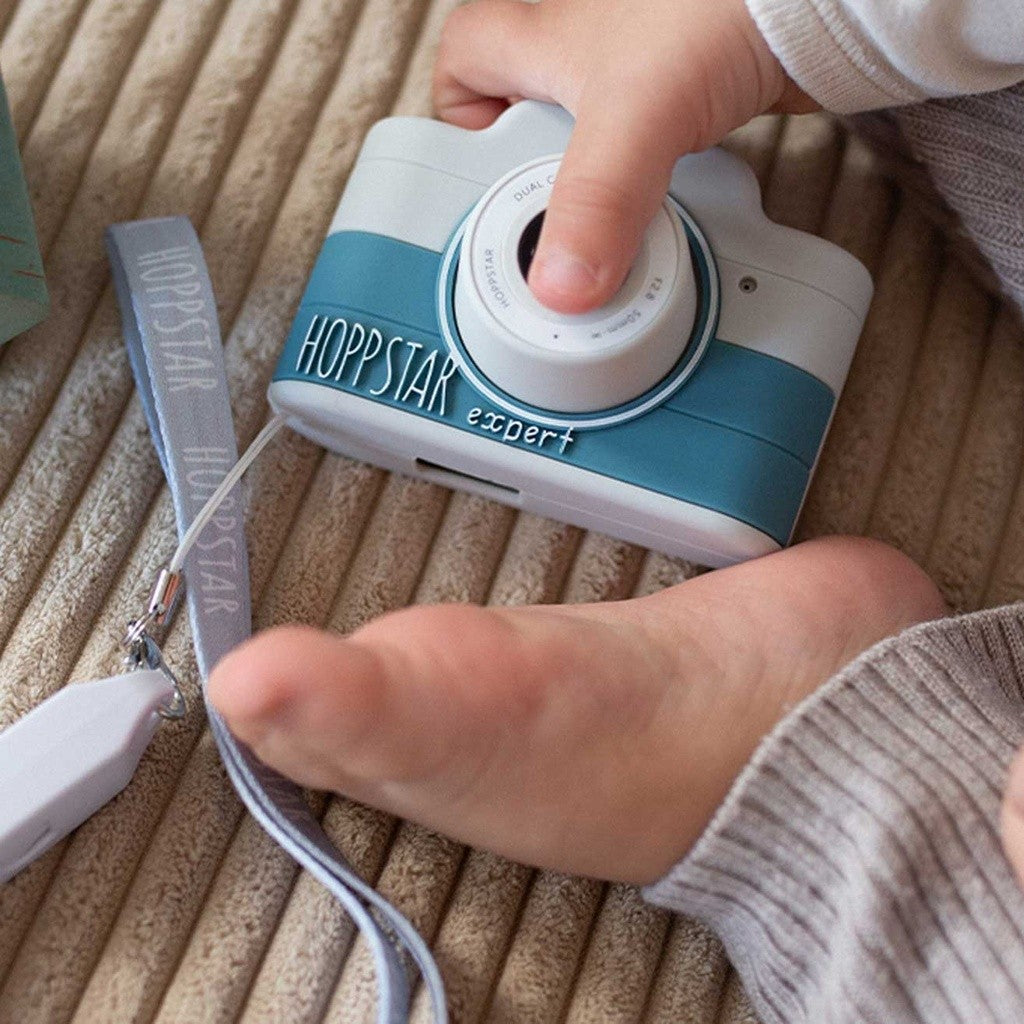 Child pressing the shutter of the blue Hoppstar Expert Yale camera