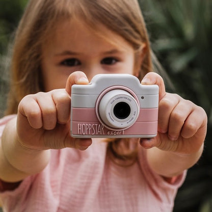 Girl holding the pink Hoppstar Expert Blush camera towards the viewer