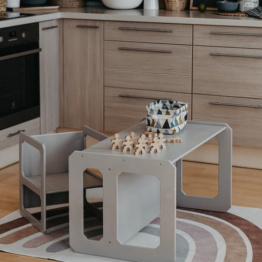 Gray Montessori weaning table and chair set in kitchen with wooden blocks and basket