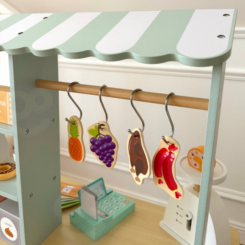 Top view of food truck awning with hanging wooden play food items on brass rod