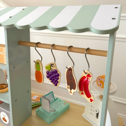 Top view of food truck awning with hanging wooden play food items on brass rod