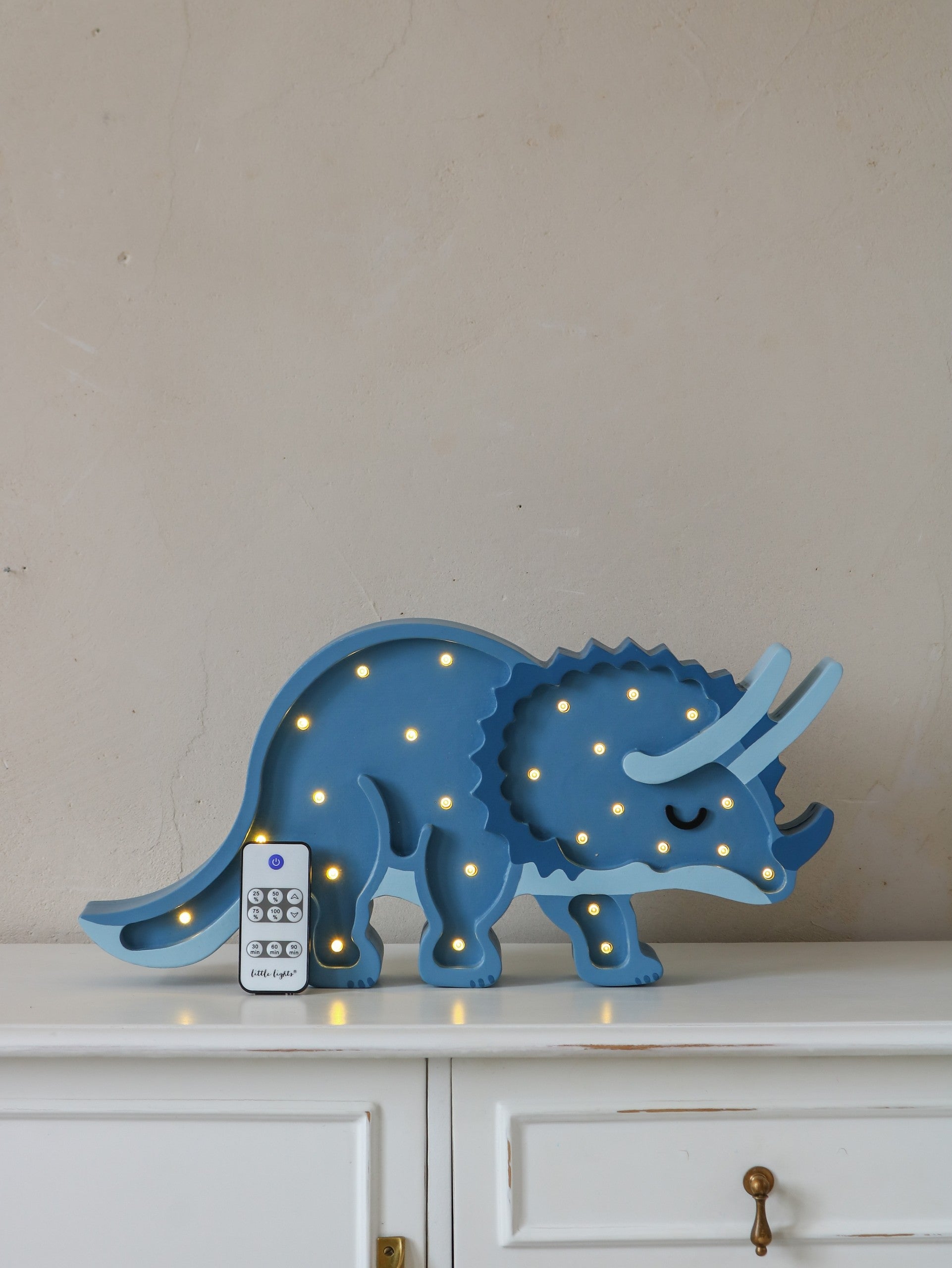Blue triceratops LED lamp with remote control and dimmer function on display shelf