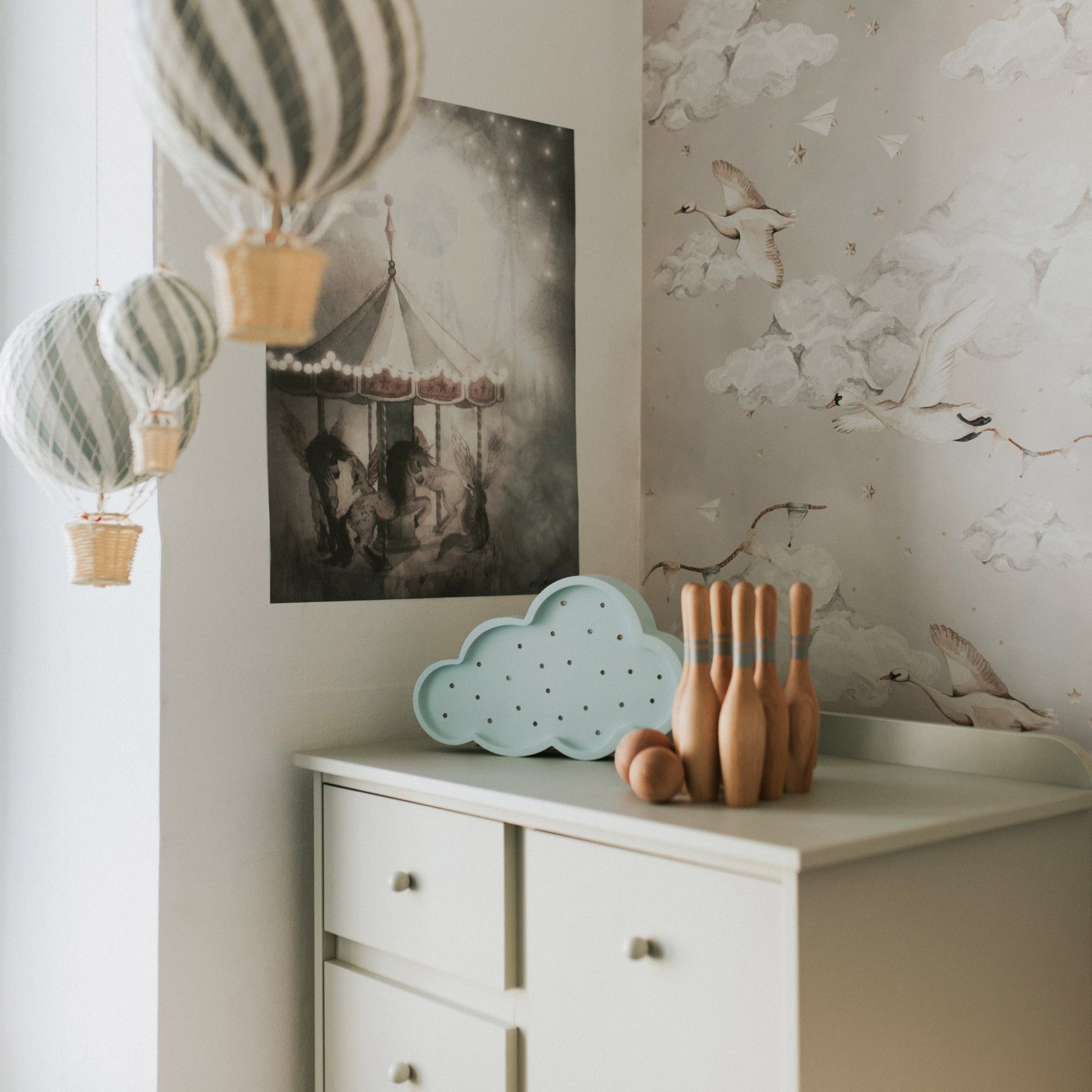 Light blue cloud lamp displayed on bedroom dresser with pampas grass and decorative items