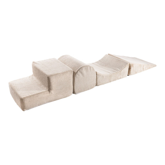 Ecru corduroy foam block set with four modular pieces arranged in a curved line, showing cube, cylinder, and wedge shapes