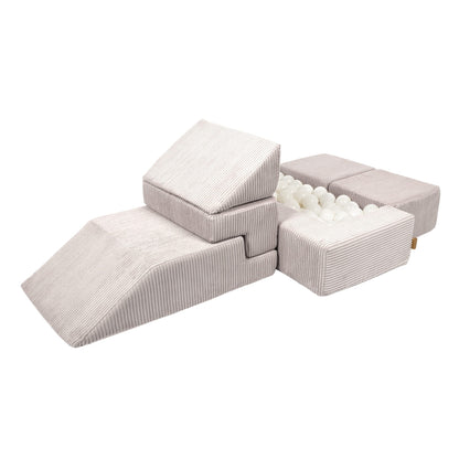 Ecru soft velvet brick blocks arranged as a modular sofa with ball pit and storage configuration