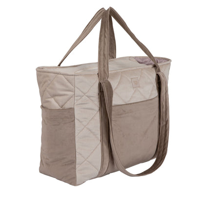 Beige mom weekender bag with quilted velvet fabric and dual handles shown from angled front view