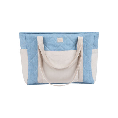 Front view of jeans weekender bag with color-blocked cream and blue design and handles
