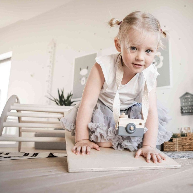 Toddler balancing on wooden climbing arch flipped as balance board