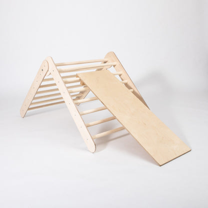 Side view of natural wood climbing triangle with attached ramp and climbing rings