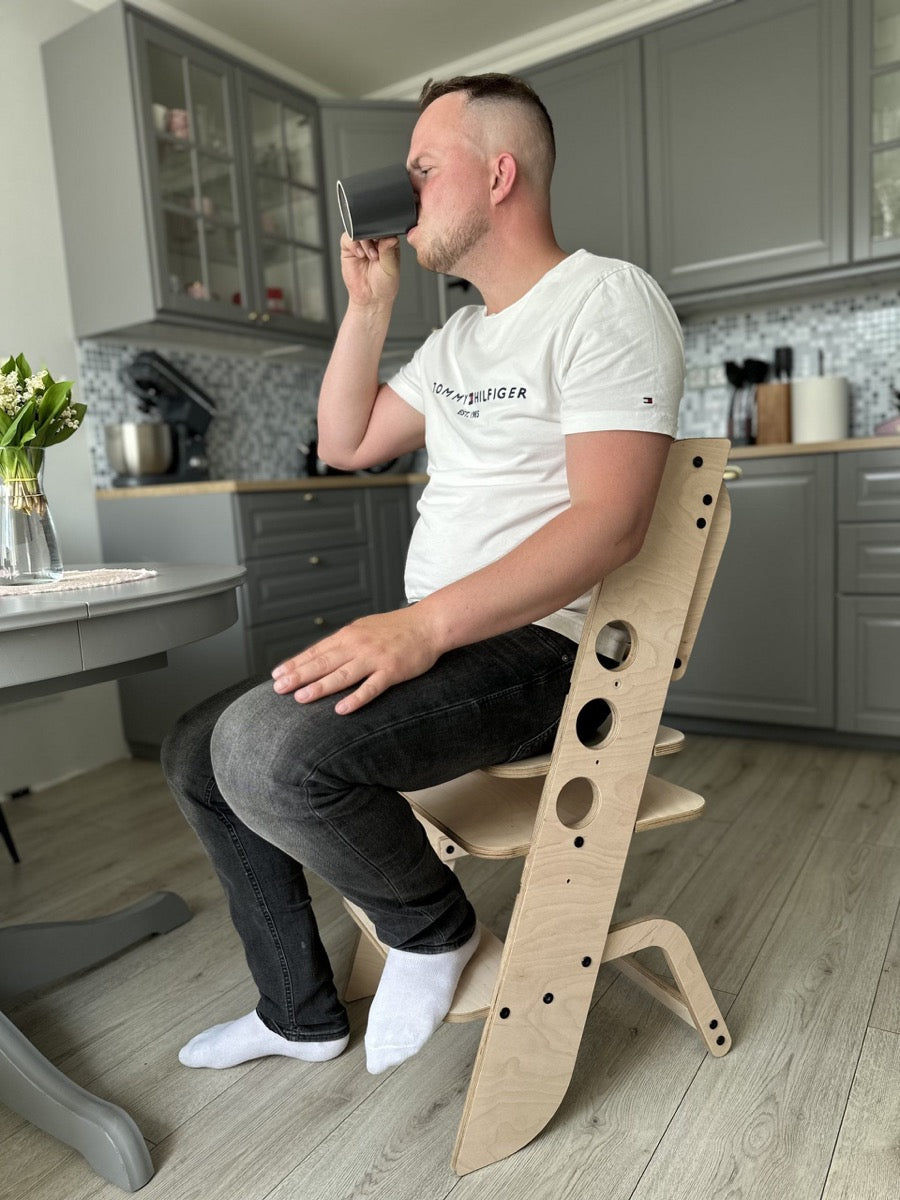 Adult male sitting in Louis learning tower demonstrating sturdy construction and adult use