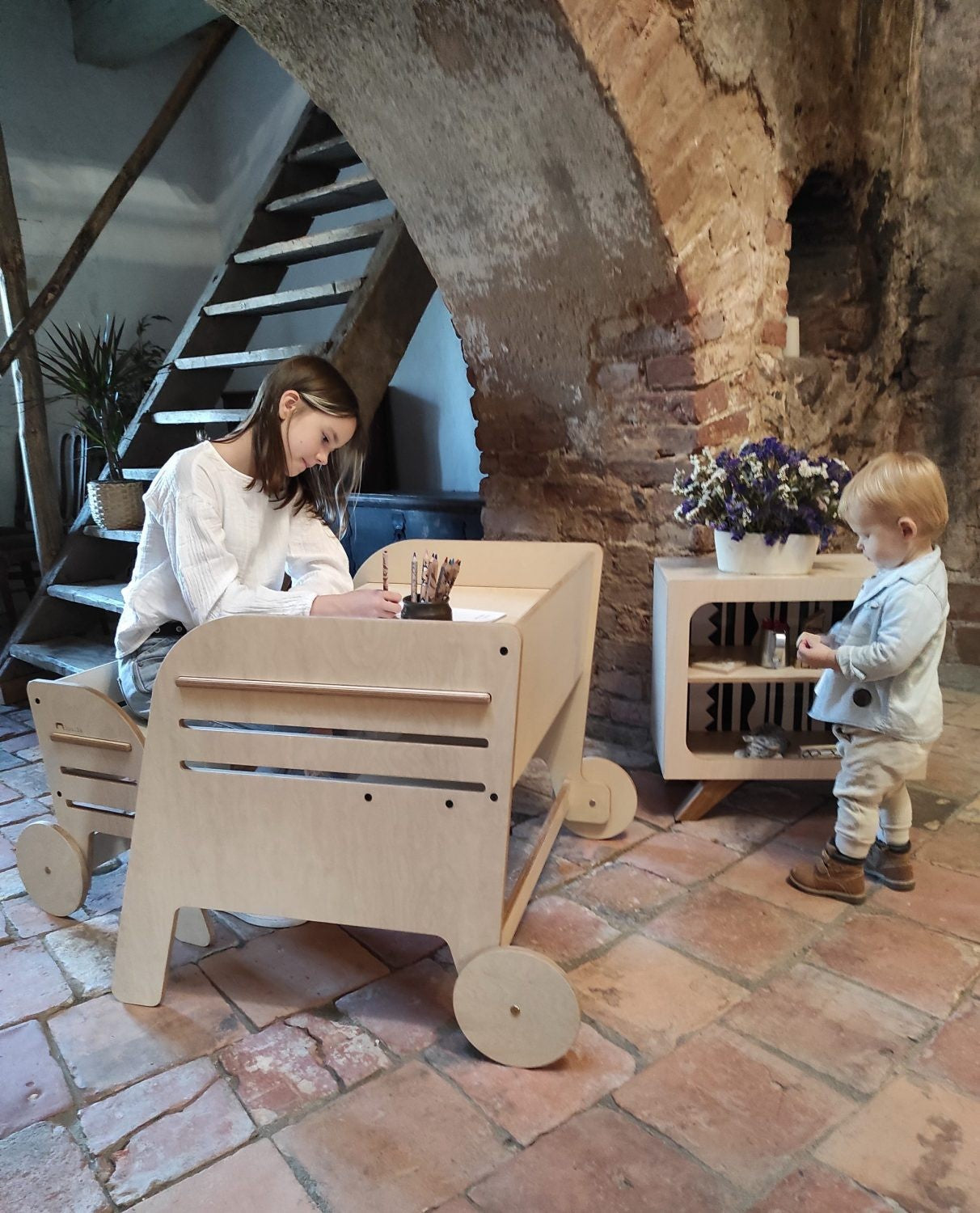 Adult and toddler using separate Montessori tables together, demonstrating scalable growth design