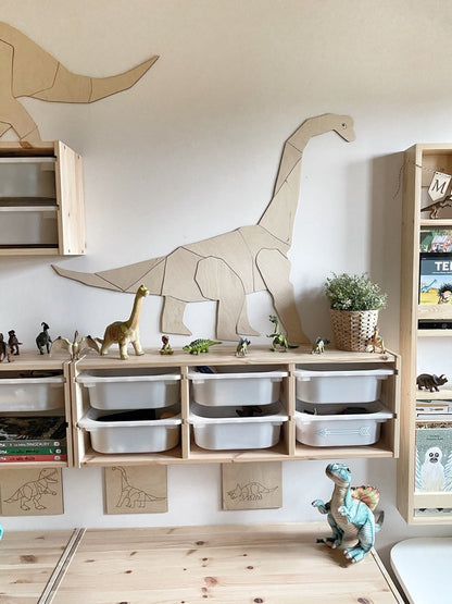 Pale wood diplodocus wall sculpture displayed above storage shelving with toy dinosaurs