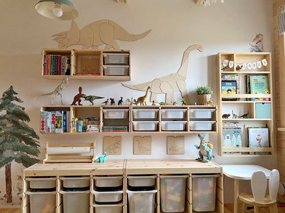 Oversized wooden diplodocus decoration spanning white shelving unit in contemporary playroom storage