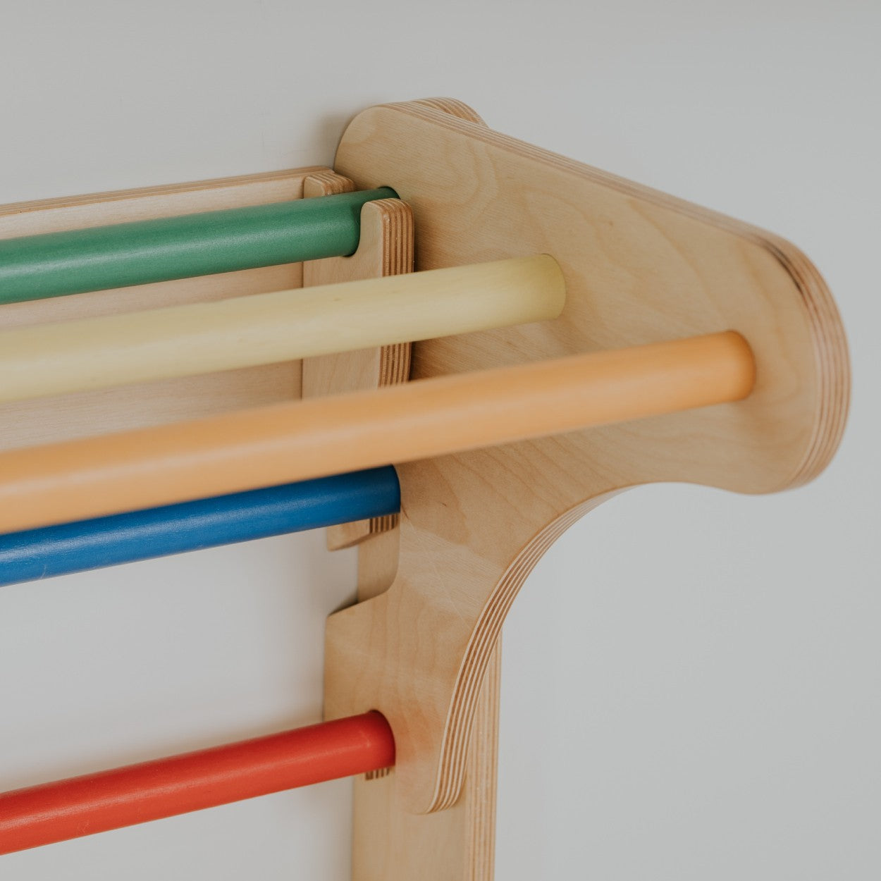 Close-up of birch plywood frame detail with colorful wooden climbing bars