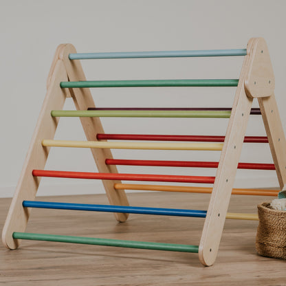 leg&go rainbow Pikler Triangle with multi-colored bars, front view on wooden floor