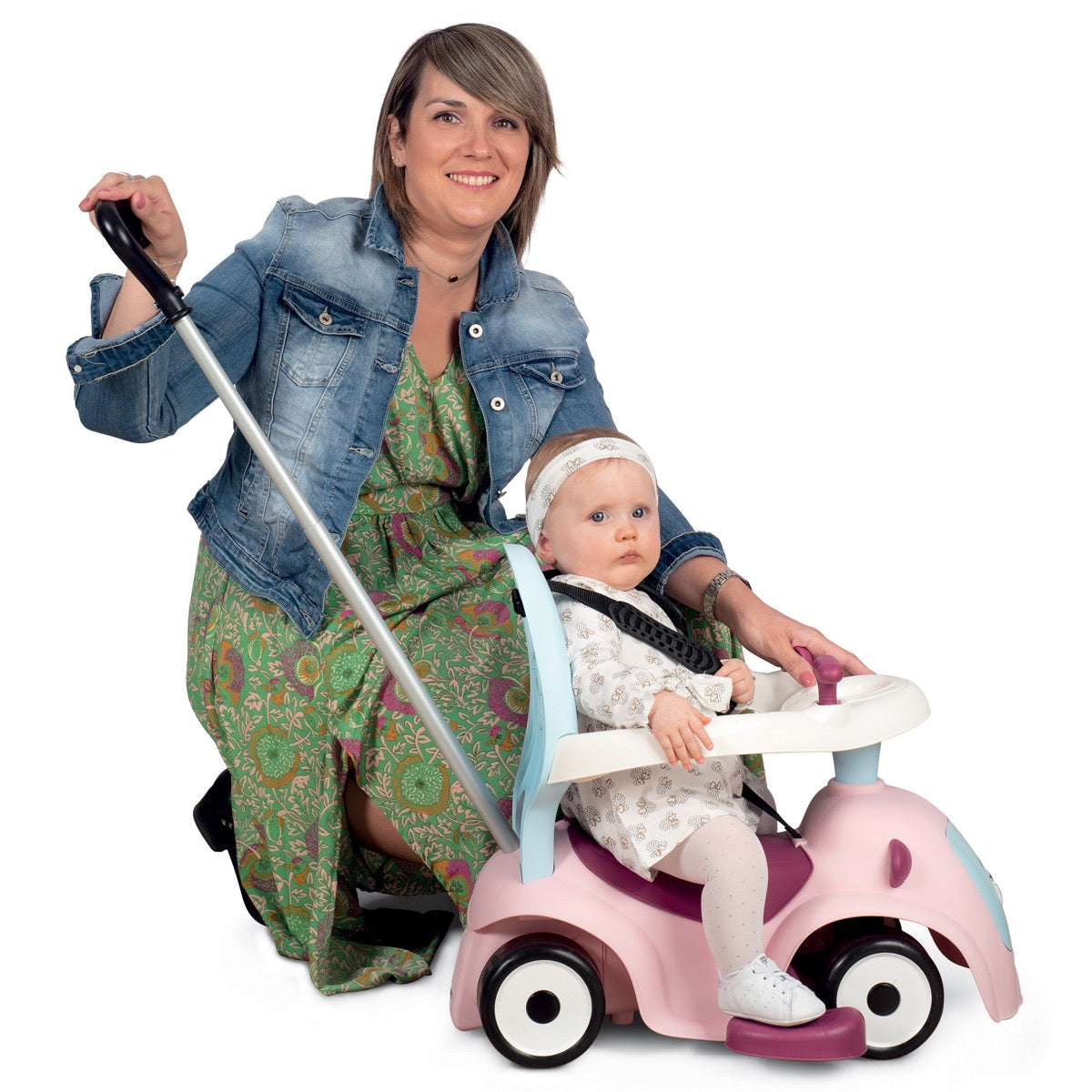 Parent using push handle to guide child on pink Maestro 3in1 ride-on with canopy