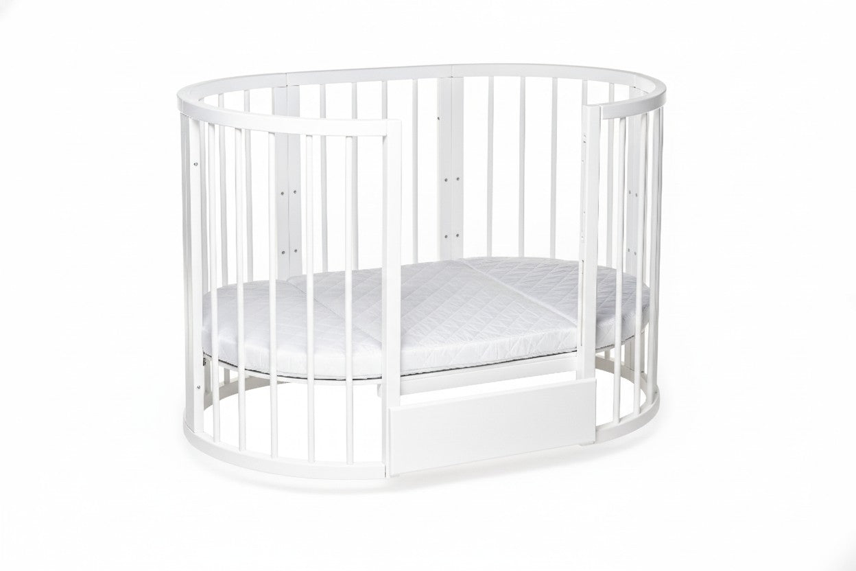 White round crib with one removable side panel and included mattress